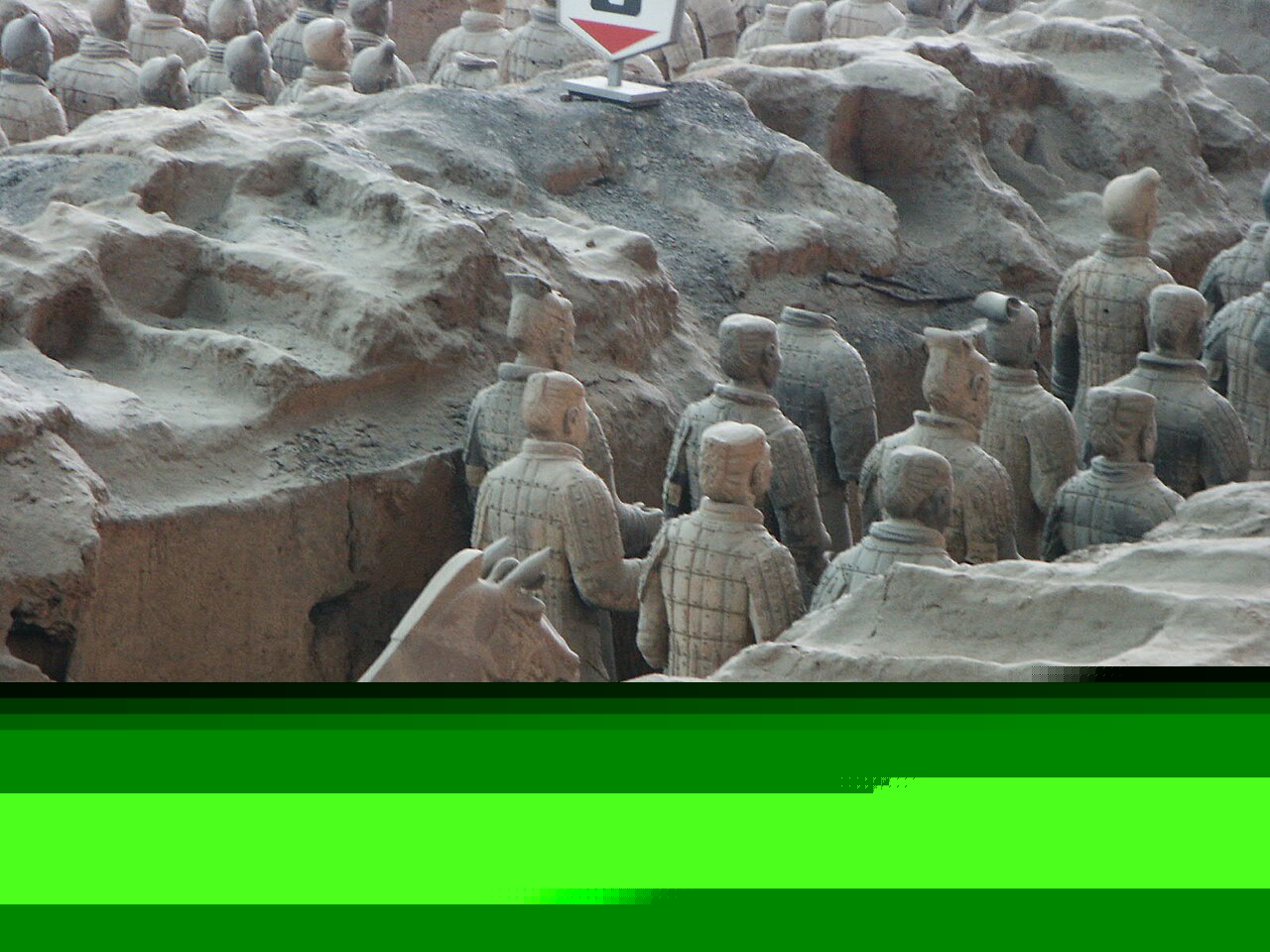 兵马俑坑内一尊陶俑的面部特写与雕刻铠甲纹路